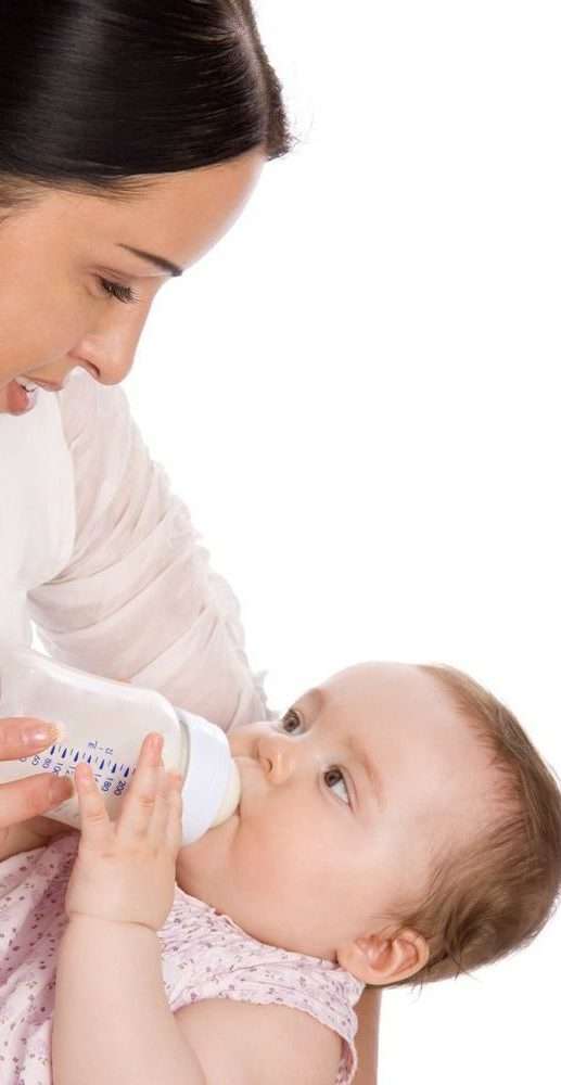 mamma mentre dà il latte alla figlia con il biberon anticolica