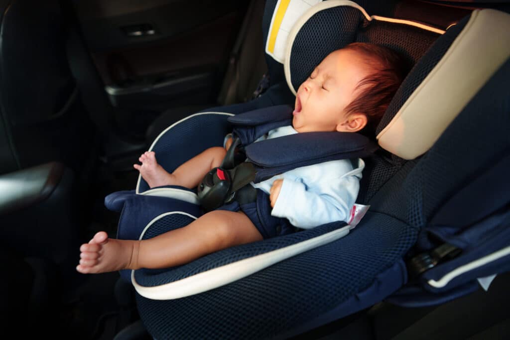 Bebè su seggiolino auto nella macchina che sbadiglia dal sonno