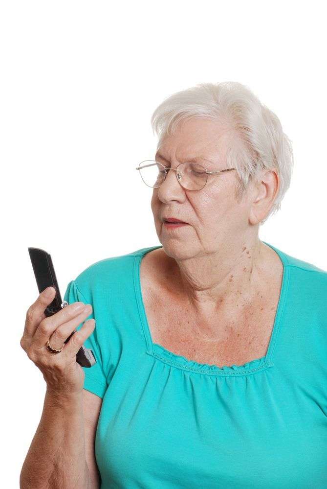 signora anziana che visualizza sms su di un cellulare a conchiglia con display