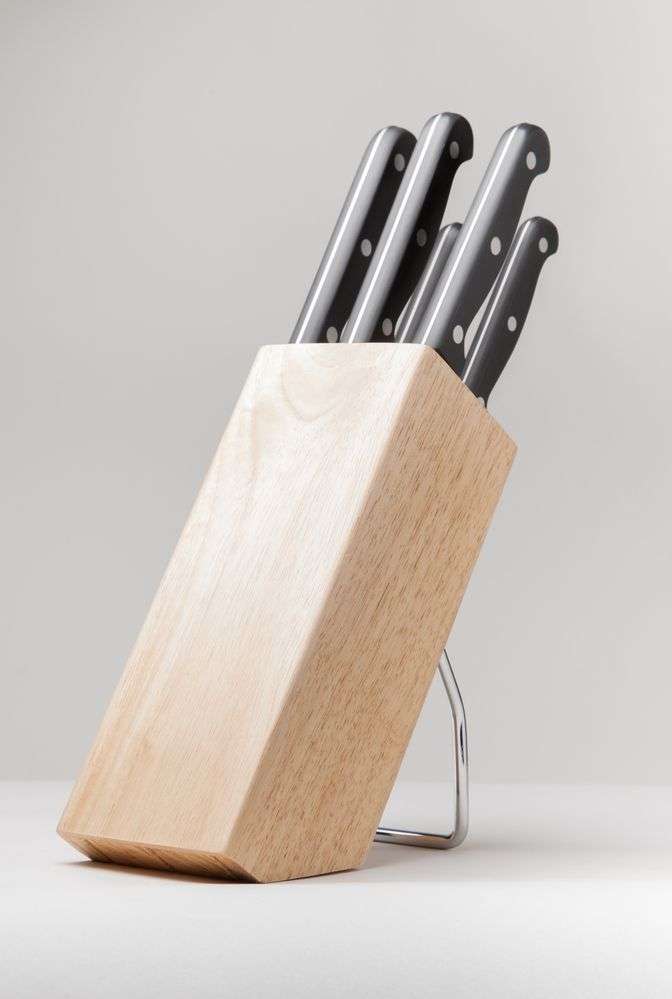 quattro coltelli da cucina in un espositore in legno