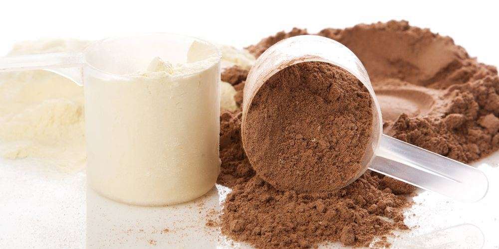 due dosatori colmi di proteine in polvere al gusto di cioccolato e vaniglia
