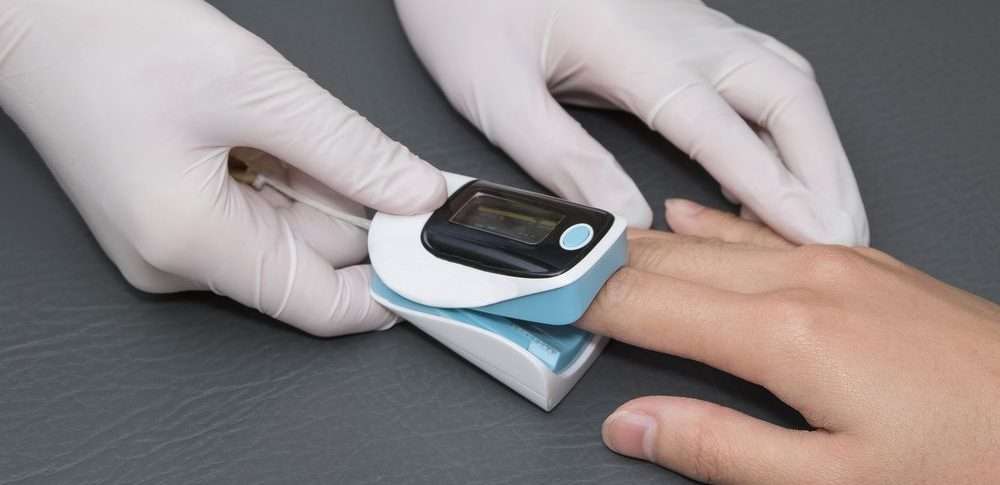 dottore durante misurazione della frequenza cardiaca tramite pulsossimetro con display